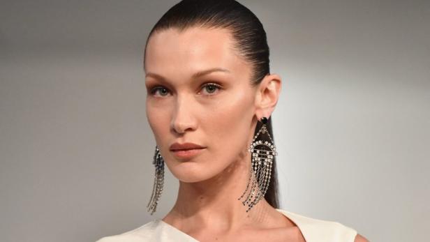 Bella Hadid trägt ein weißes Kleid und auffällige Ohrringe.