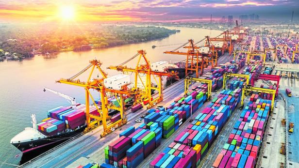 Logistics and transportation of Container Cargo ship and Cargo plane with working crane bridge in shipyard at sunrise, logistic import export and transport industry background