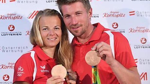 Zwei österreichische Sportler präsentieren stolz ihre Bronzemedaillen.