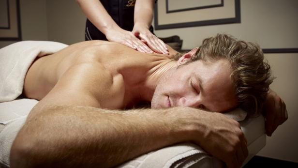 Ein Mann liegt auf einer Massageliege und bekommt eine Rückenmassage.