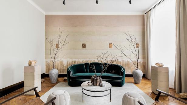 Ein Wohnzimmer mit einem grünen Sofa, einem Couchtisch und dekorativen Elementen.