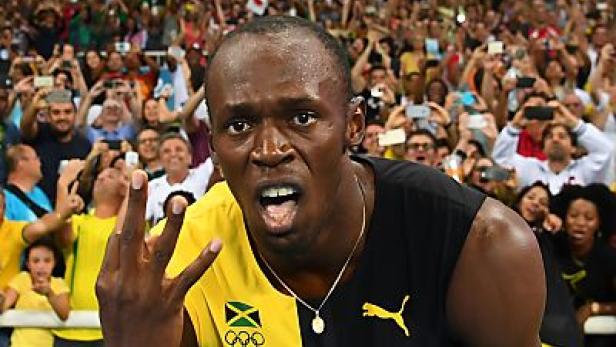 Usain Bolt jubelt vor einer jubelnden Menschenmenge.