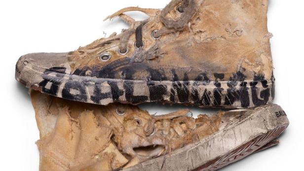 Zwei stark abgenutzte und beschädigte High-Top-Sneakers der Marke Balenciaga liegen übereinander.