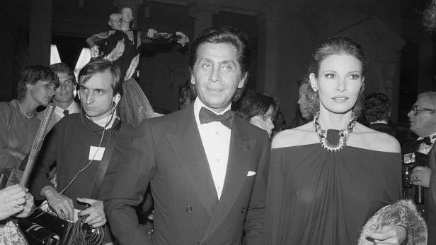 Valentino Garavani und Raquel Welch posieren bei einer Veranstaltung.