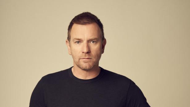 Ewan McGregor posiert mit den Händen in den Hosentaschen.