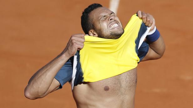 Ein Tennisspieler zerreißt frustriert sein gelbes Trikot.