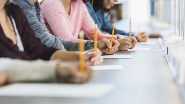 Cropped view of group of teenagers taking a test