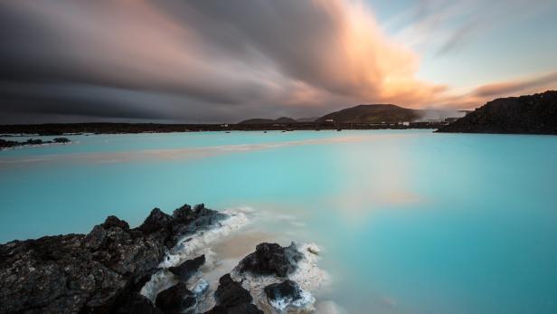 Die Blaue Lagune in Island mit milchig-blauem Wasser und dunklem Lavagestein.