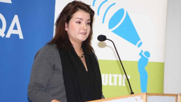 Eine Frau spricht bei einer Präsentation am Rednerpult.