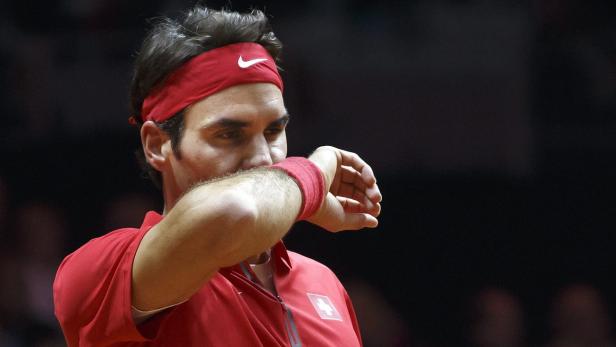 Roger Federer wischt sich den Schweiß von der Stirn.