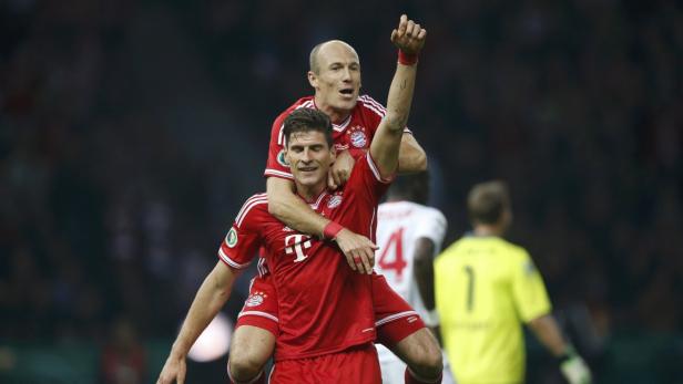 Bayern Munich&#039;s Mario Gomez celebrates with team mate Arjen Robben (top) after scoring a goal against VfB Stuttgart during their German soccer cup (DFB Pokal) final match at the Olympic Stadium in Berlin June 1, 2013. REUTERS/Tobias Schwarz (GERMANY - Tags: SPORT SOCCER) DFB RULES PROHIBIT USE IN MMS SERVICES VIA HANDHELD DEVICES UNTIL TWO HOURS AFTER A MATCH AND ANY USAGE ON INTERNET OR ONLINE MEDIA SIMULATING VIDEO FOOTAGE DURING THE MATCH.