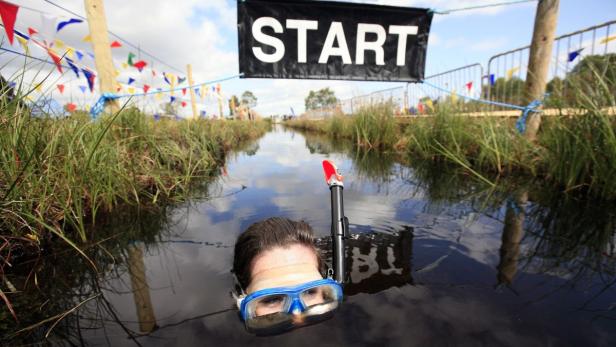 RNPS IMAGES OF THE YEAR 2009 - A competitor crosses the Start/Finish line during the Northern Ireland Bog Snorkeling Championships in Peatlands Park, Dungannon, County Tyrone July 26, 2009. REUTERS/Cathal McNaughton (NORTHERN IRELAND SOCIETY SPORT SWIMMING IMAGES OF THE DAY)