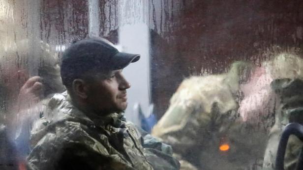Ukrainische Soldaten aus dem Stahlwerk werden von prorussischen Kräften weggebracht.