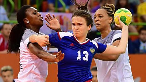 Eine Handballspielerin im blauen Trikot mit der Nummer 13 wirft den Ball.