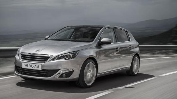 Ein silberner Peugeot 308 fährt auf einer Landstraße.