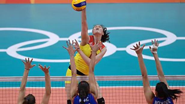 Eine Volleyballspielerin schlägt den Ball über das Netz.