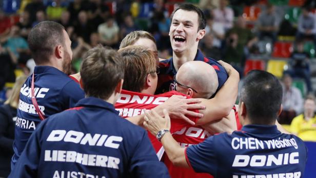 Ein jubelndes Tischtennis-Team umarmt sich nach einem Sieg.