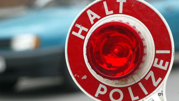 Ein rotes Polizeikontrollschild mit der Aufschrift „Halt Polizei“.