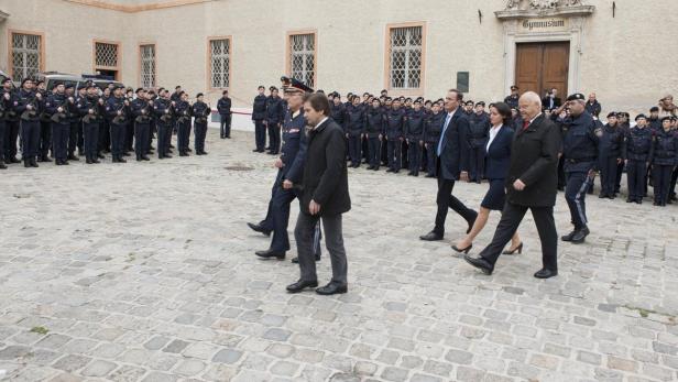 Eine Gruppe von Personen geht an einer Reihe von Polizisten vorbei.