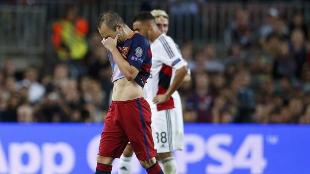 Ein Fußballspieler verdeckt sein Gesicht mit der Hand, möglicherweise enttäuscht über das Ergebnis.