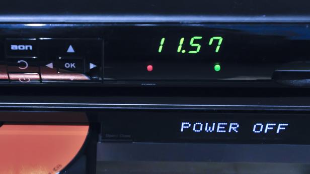 Ein elektronisches Gerät zeigt die Uhrzeit 11:57 und „Power Off“ an.