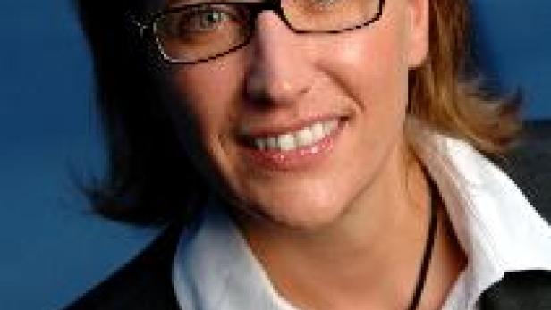 Eine Frau mit Brille lächelt in die Kamera.