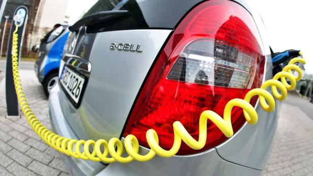 Ein Opel e-Cell wird mit einem gelben Kabel an einer Ladestation aufgeladen.