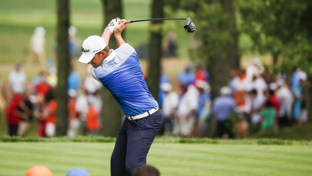 Ein Golfer schwingt seinen Schläger auf einem Golfplatz.