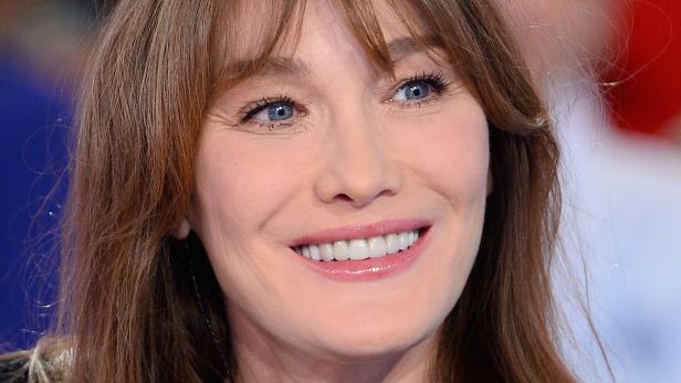 Ein Porträt von Carla Bruni mit einem freundlichen Lächeln.