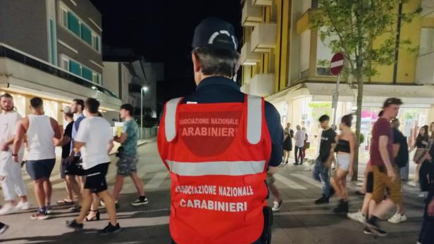 Ein Mitglied der Associazione Nazionale Carabinieri steht auf einer belebten Straße.