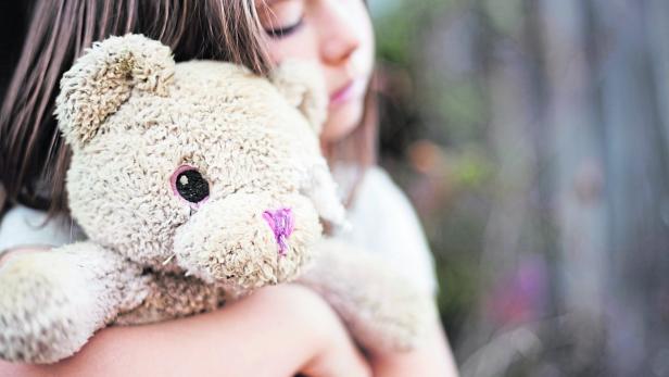 Sad Young Girl Hugging Old, Raggedy Teddy Bear