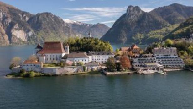 Das Schloss Ort am Traunsee in Österreich vor einer Bergkulisse.