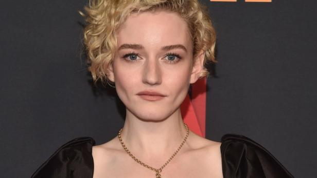 Julia Garner auf dem roten Teppich in einem schwarzen Top mit Puffärmeln.