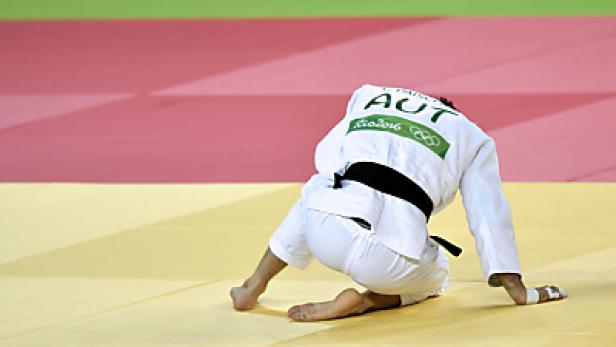 Ein Judoka aus Österreich kniet auf der Matte.
