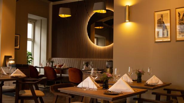 Ein elegant eingerichtetes Restaurant mit gedeckten Tischen und gedämpfter Beleuchtung.
