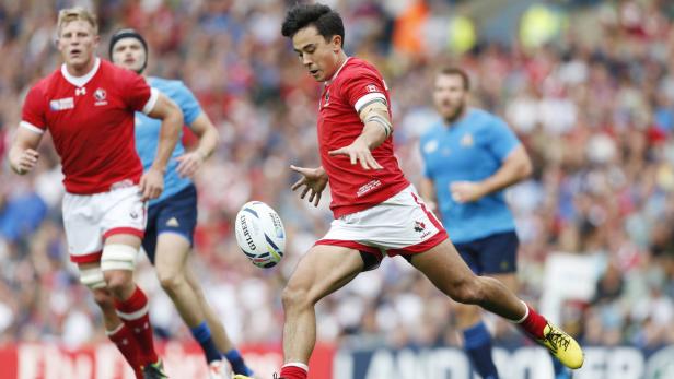 Ein kanadischer Rugbyspieler tritt den Ball während eines Spiels.