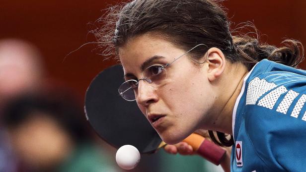Eine Frau mit Brille spielt Tischtennis.