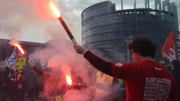 Demonstranten zünden vor dem Europäischen Parlament in Straßburg Bengalos.
