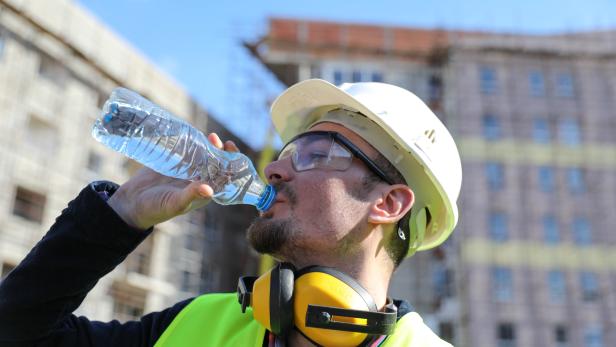 boss at construction site with bottle of water, close up