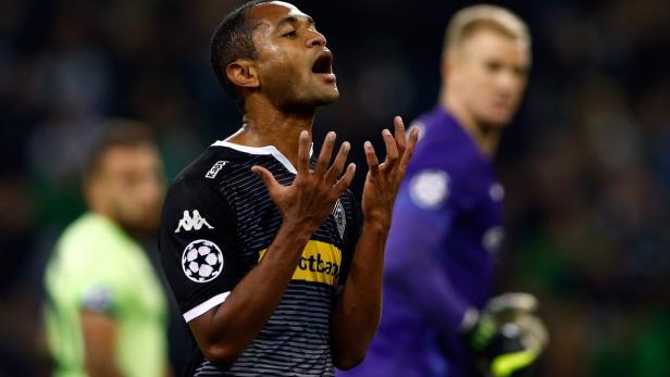 Ein Fußballspieler in einem schwarz-weißen Trikot gestikuliert auf dem Spielfeld.