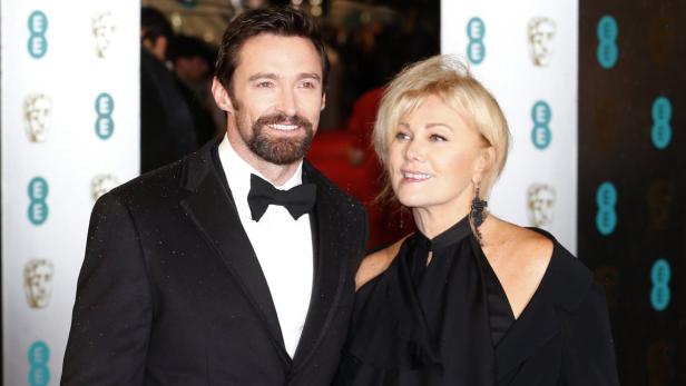 Actor Hugh Jackman (L) and his wife Deborra-Lee Furness pose as they arrive for the British Academy of Film and Arts (BAFTA) awards ceremony at the Royal Opera House in London February 10, 2013. REUTERS/Suzanne Plunkett (BRITAIN - Tags: ENTERTAINMENT) (BAFTA-ARRIVALS)