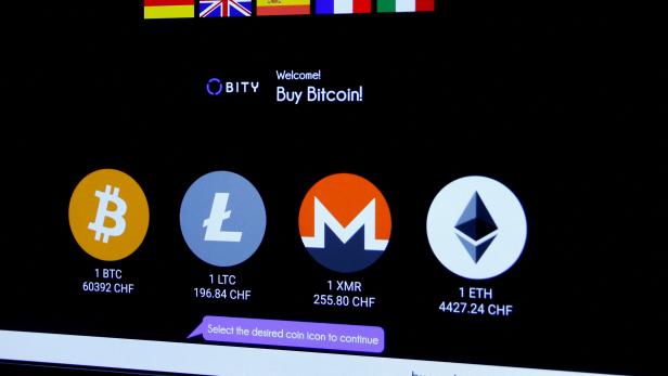 FILE PHOTO: Logos and exchange rates of Bitcoin, Litecoin, Monero and Ether to Swiss franc are seen on a cryptocurrency ATM in Zurich