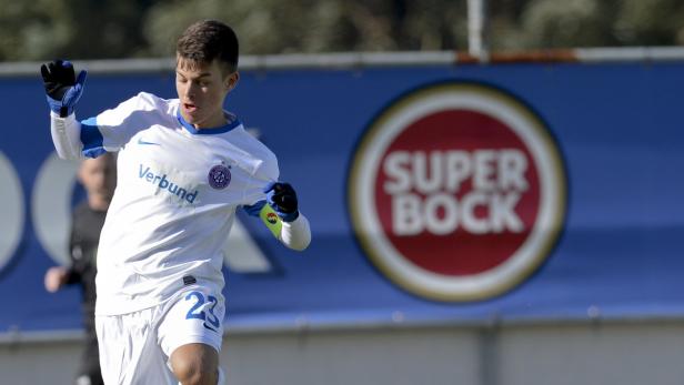 Ein junger Fußballspieler in weiß-blauem Trikot jubelt auf dem Spielfeld.