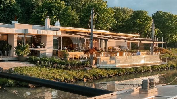 Ein modernes Restaurant befindet sich am Ufer eines Flusses.