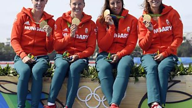 Vier ungarische Sportlerinnen sitzen mit Goldmedaillen auf dem Siegerpodest.