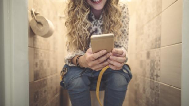 Scrollen am Klo: Warum wir immer öfter mit dem Handy auf der Toilette sind