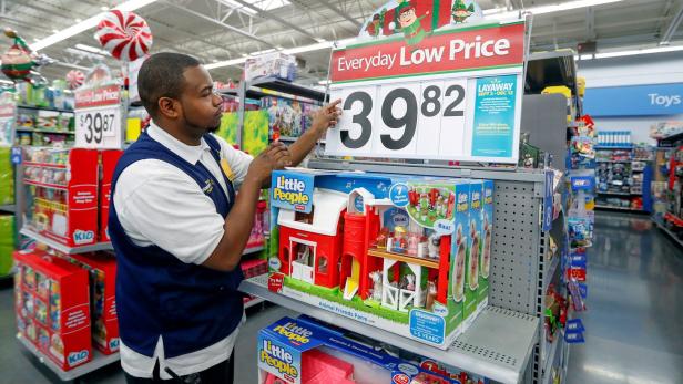 Ein Mitarbeiter in einem Supermarkt präsentiert ein „Little People“-Spielzeugbauernhof für 39,82 Dollar.