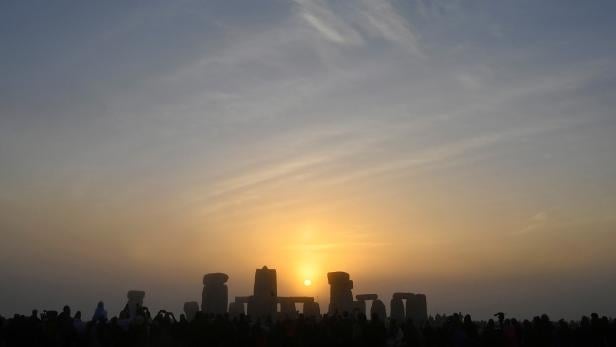 Revellers gather to celebrate the Summer Solstice at sunrise at Stonehenge stone circle near Amesbury