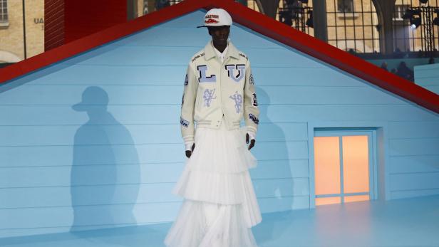 Ein Model in einer Louis Vuitton Jacke und einem weißen Tüllrock auf einem Laufsteg.