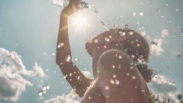 Woman cooling herself with water on a hot summer day